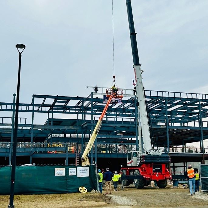 The Topping Off beam is hoisted in place and installed
